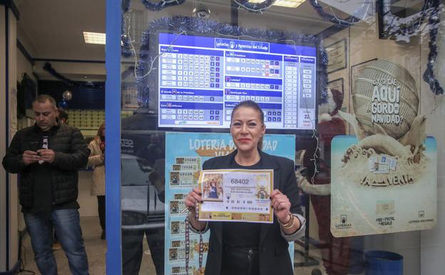 La dueña de la administración de lotería situada en la calle Carretas,12 de Villaviciosa de Odón (Madrid), posa con el número premiado.