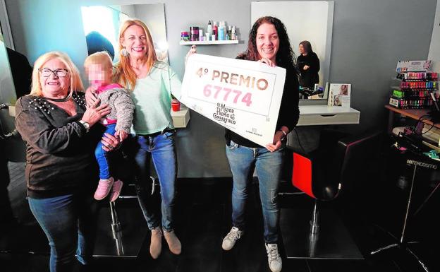 Silvia Soriano, a la derecha, y Carmen Tatay, al lado, posan con el cartel que indica que han sido agraciadas con el cuarto premio.