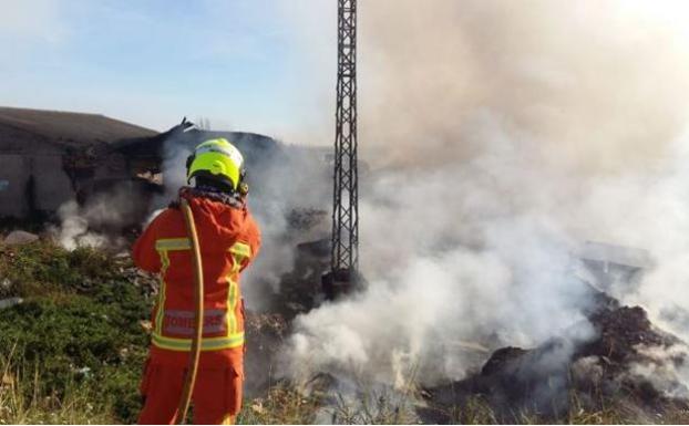 Un bombero controla el fuego en la fábrica de Sollana. 