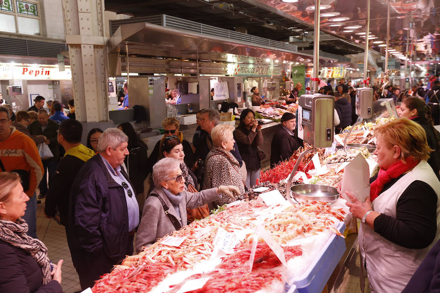 Lleno hasta la bandera. Así ha estado este sábado el centro de Valencia con curiosos que querían fotografiar todos los escaparates, pero sobre todo con gente haciendo las compras de Nochevieja. Uno de los puntos de encuentro que ha registrado el cartel de 'completo' ha sido una vez más el Mercado Central. El marisco, salazones, frutos secos y quesos variados llenan las cestas a dos días del Fin de Año. 