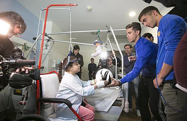 Gabriel Paulista entrega un balón a una de las niñas hospitalizadas que los futbolistas visitaron ayer. 