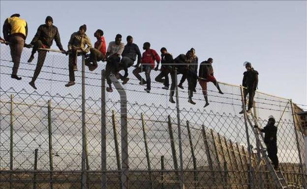 Inmigrantes encaramados a la valla de Melilla. 