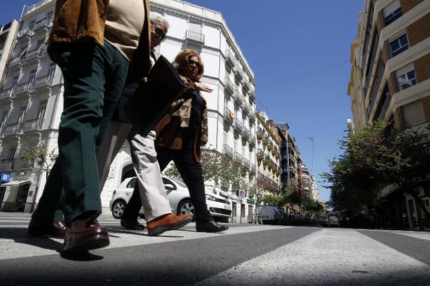 Varios peatones cruzan Cirilo Amorós. 
