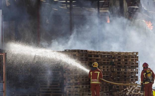 Los bomberos intervienen en el indencio producido ayer en una empresa de Manises.