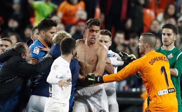 El jugador del Valencia, Gabriel Paulista (c) sangra tras recibir un golpe durante el partido de cuartos de fina de la Copa del Rey contra el Getafe.