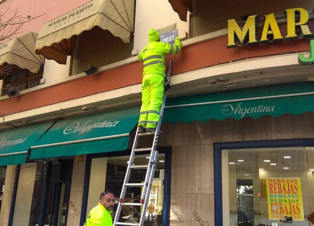 Un operario cambia las placas de la avenida del Oeste a su denominación en valenciano, ayer. 