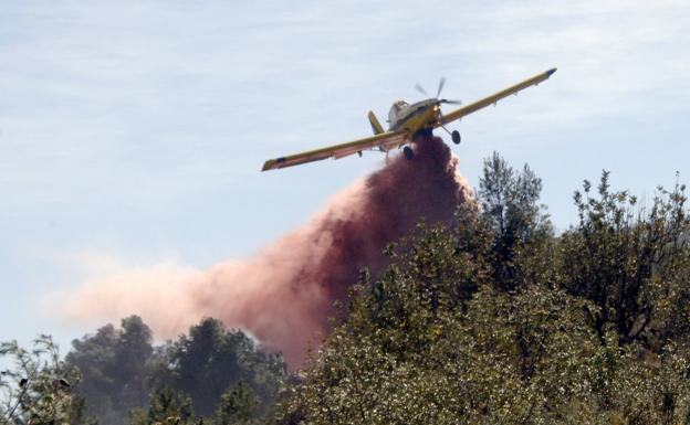 Un avión suelta agua en un incendio en la Calderona. 