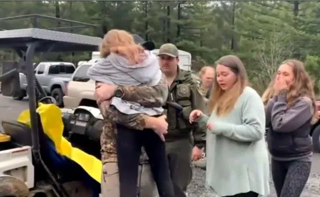 Una de las niñas rescatadas en el bosque se abraza a su familia. 