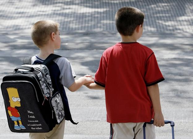 Dos niños de Primaria se dirigen a su colegio en el primer día de clase. 