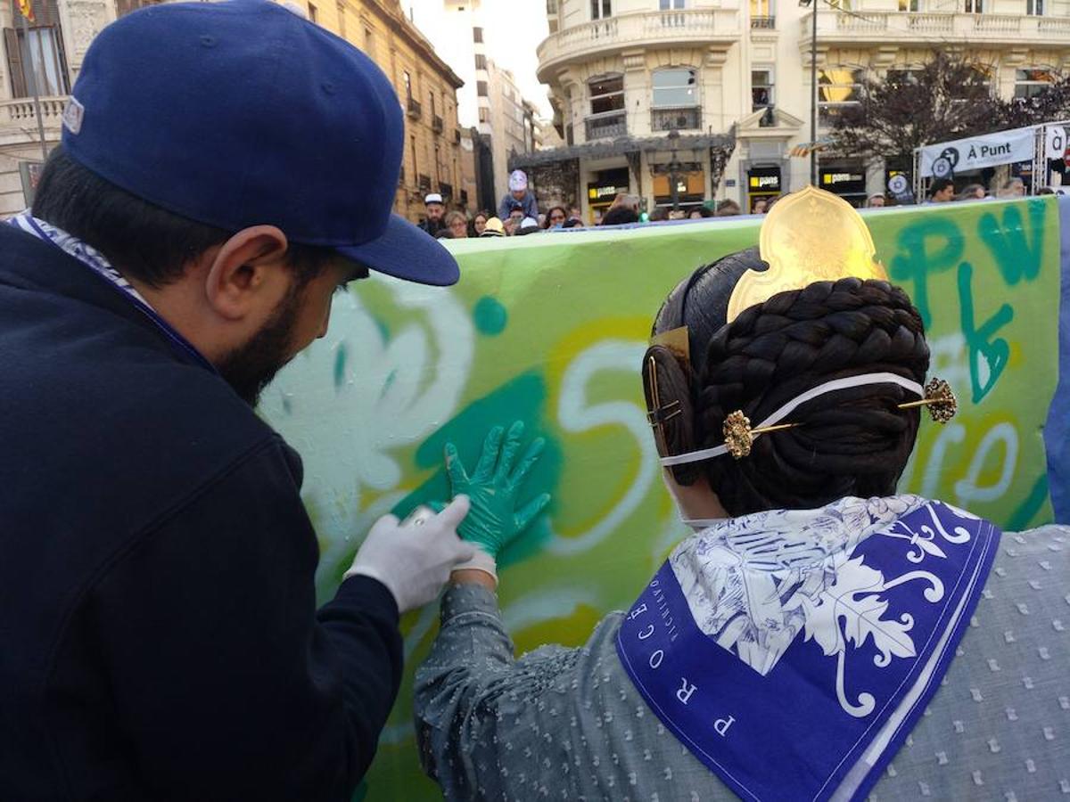 Los artistas urbanos Pichiavo, responsables del diseño de la falla de este año, y los artistas falleros que la han creado, Latorre y Sanz, participan este sábado en una pintada colectiva del monumento de la Plaza del Ayuntamiento. 