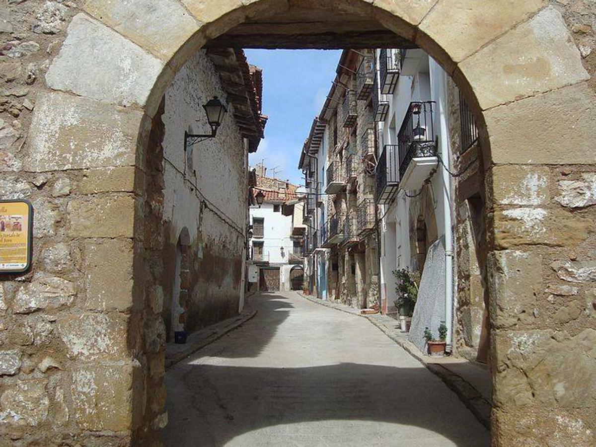 Vistabella del Maestrazgo (Castellón). Escaparse a Vistabella se puede resumir con dos palabras: montaña y naturaleza, puesto que es la entrada más conocida al Parque Natural de Peñagolosa, lo que lo hace más atractivo para aquellos que quieran practicar una ruta. Esta villa de origen medieval conserva gran parte de la muralla que protegía al pueblo. Destaca el Santuario de San Juan de Peñagolosa, construido en el s.XVI y el puente romano. Además, los visitantes no pueden perderse algunos de sus platos más típicos como el tombet o la olla amb pilotes ni su embutido.