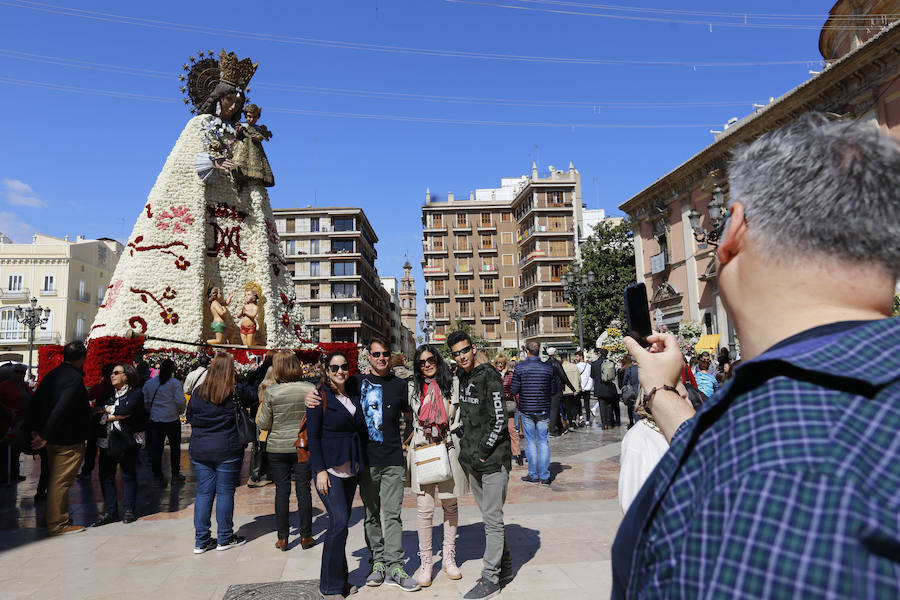 La Ofrenda concluyó este lunes después de que miles de falleros desfilaran para llevar las flores a la Virgen de los Desamparados. Este martes, a la luz del día se ha desvelado ante los ojos de los valencianos el aspecto definitivo del manto de la 'Geperudeta'. Claveles blancos, rojos y rosas componen componen el diseño del vestidor Rafael Chordá. Un floreado manto con el blanco como color predominante y que preside estos días la plaza de la Virgen, ante su basílica.