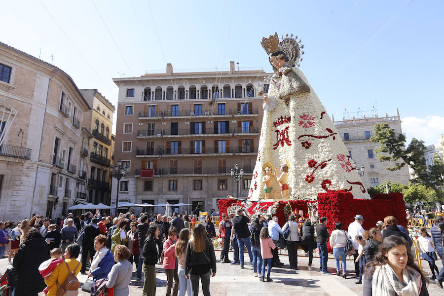 La Ofrenda concluyó este lunes después de que miles de falleros desfilaran para llevar las flores a la Virgen de los Desamparados. Este martes, a la luz del día se ha desvelado ante los ojos de los valencianos el aspecto definitivo del manto de la 'Geperudeta'. Claveles blancos, rojos y rosas componen componen el diseño del vestidor Rafael Chordá. Un floreado manto con el blanco como color predominante y que preside estos días la plaza de la Virgen, ante su basílica.