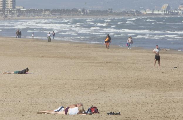 La playa de la Malvarrosa, ayer, con varias personas paseando y tomando el sol. 