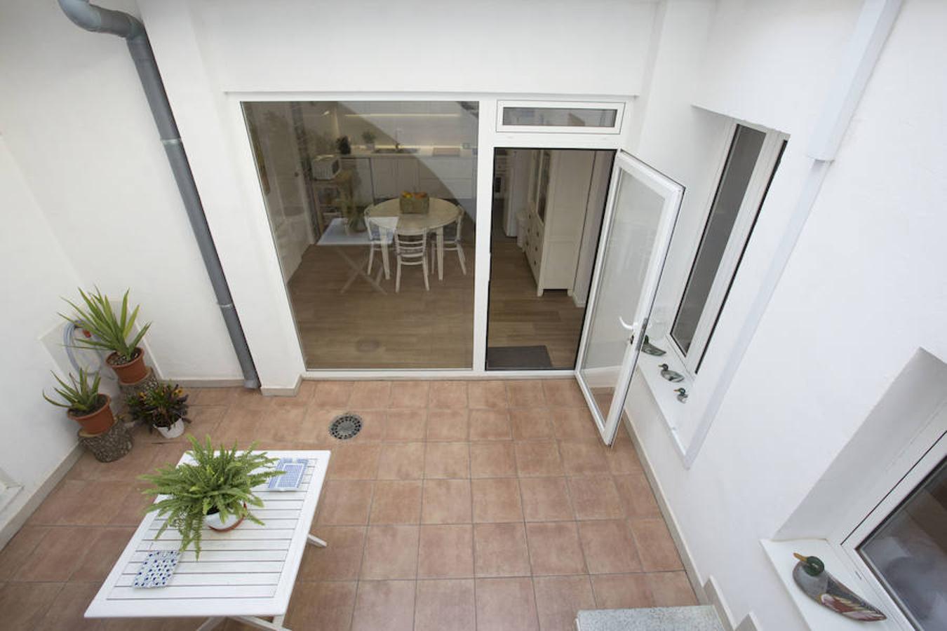 Fue en Puçol, en una calle desde la que se divisan huertos de naranjos, donde dieron con la casa de los años sesenta que hoy acoge su hogar. Su objetivo principal a la hora de abordar la reforma era darle luz, y para ello quitaron la habitación de la entrada y la integraron con el salón. Tanto la cocina y el salón como la habitación principal comunican con un patio salpicado de plantas que vehicula las diferentes partes de la casa dotándolas de luz natural. En la casa de Puçol han encontrado, precisamente, el espacio que necesitaban tanto para vivir cómodamente como para trabajar, con capacidad de almacenaje que antes no tenían en un piso. Algunos de los muebles, como la mesa del salón, los trajeron de un estudio que tenía Juan, prestigioso diseñador gráfico.En la planta de arriba, en una habitación grande en la que el antiguo propietario tenía pájaros, han instalado un estudio que comparten los dos. Sobre la mesa de trabajo de María José reposan algunos de los collages en los que está trabajando. La pared en la que se encuentra la zona de trabajo de Juan está cubierta por obras de Tintín. Las más pequeñas son láminas y las más grandes serigrafías numeradas que compró en Londres y en París cuando iba a las ferias de diseño. También tiene, protegida por una urna de metacrilato, una figura de resina del capitán Haddock, Tintín y Milú que le regaló un amigo que se la trajo de Bruselas. «Tenía unos ocho años cuando una tía mía me regaló 'El Tesoro de Rackham el Rojo', no recuerdo ni las veces que lo leí, lo tenía desgastado, pasaba horas mirando todos los detalles. Lo he leído todo, hasta 'Tintín en el país de los Soviets', que fue la primera obra que Hergé sacó en blanco y negro», detalla Juan.