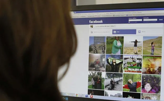 Una mujer, viendo en Facebook una página de mujeres iraníes sin velo.