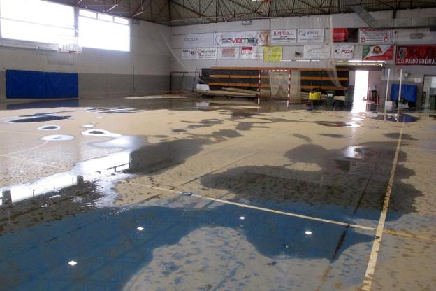 El pabellón del polideportivo municipal de Dénia, ayer, todavía con restos del agua que había entrado el domingo y con la pista cubierta por una capa de barro. 