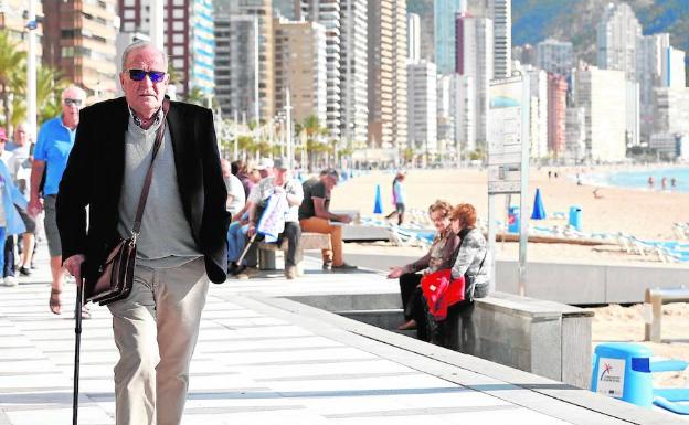 Un jubilado, paseando en la playa de Benidorm en temporada de invierno. 