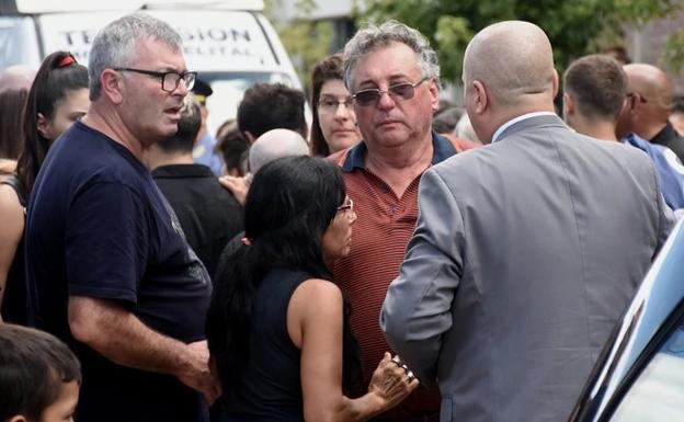 Horacio, de naranja y con gafas en el centro, durante el velatorio de su hijo Emiliano