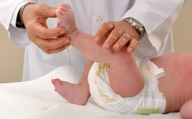Un pediatra atiende a un bebé.
