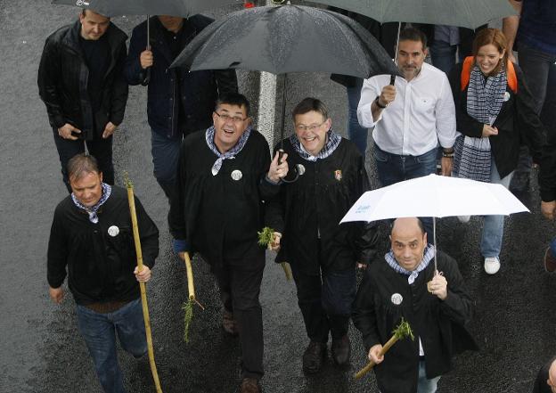 Enric Morera y Ximo Puig, bajo un paraguas en Alicante.