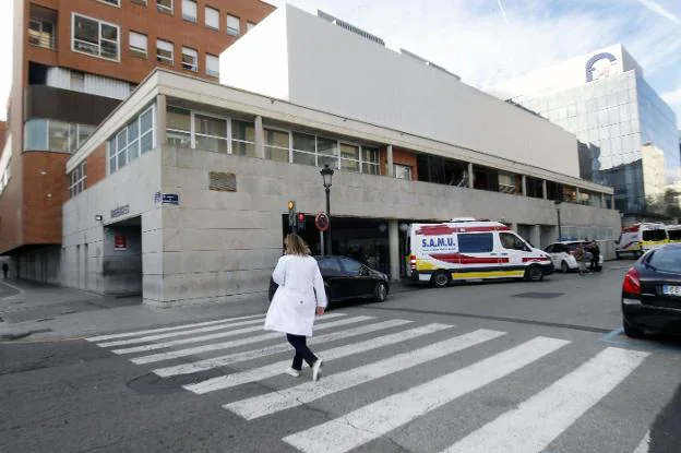 Una sanitaria cruza un paso de peatones junto al Hospital Clínico. 