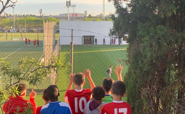 Varios niños, intentando ver el entrenamiento a puerta cerrada del Valencia CF.