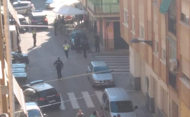 Un grupo de policías y vecinos en la calle donde el hombre realizó los disparos.