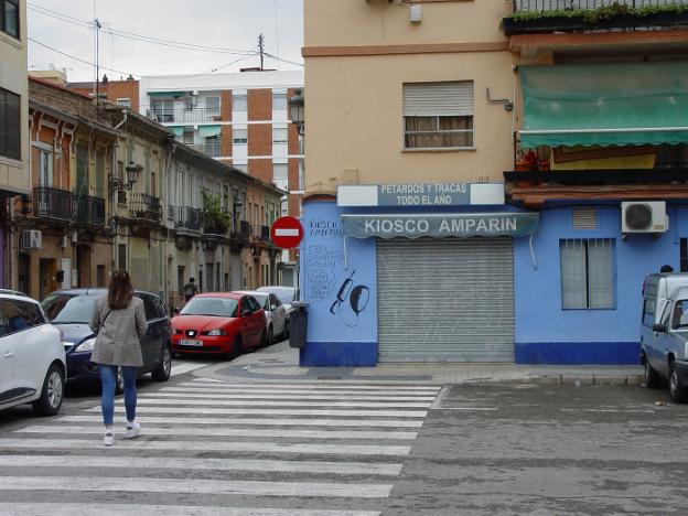 Una mujer cruza un paso de peatones junto al quiosco de Valencia donde vendían droga. 