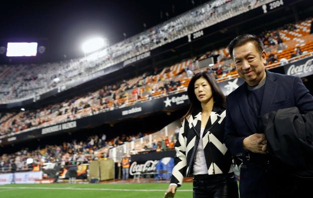 Peter Lim, junto a
su mujer, Cherie,
en el césped de
Mestalla. 