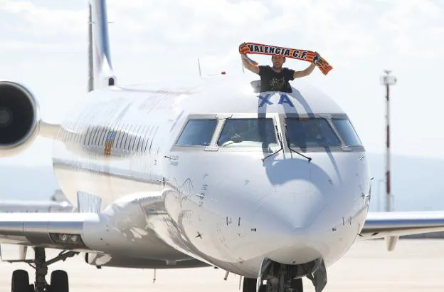 Parejo muestra una
bandera del
Valencia durante
la llegada del
avión a Manises.
