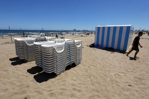 Montaje de quioscos y hamacas, este jueves, en la playa del Cabanyal. 