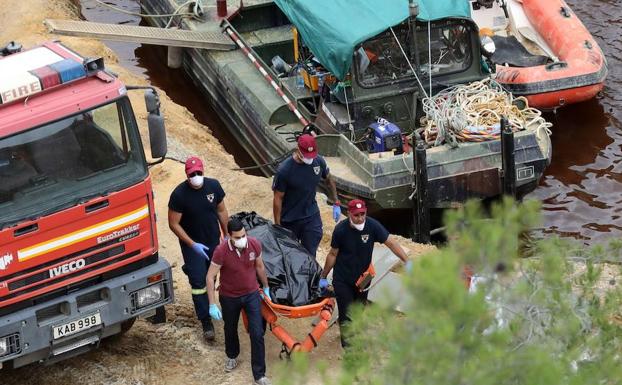 Miembros del operativo de rescate transportan un cadáver hallado este martes en el lago Mitsero, en Nicosia. 