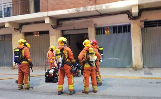 Bomberos frente a la finca donde se ha producido en incendio. 