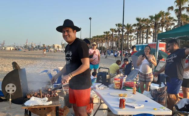 Enri Gutiérrez con su familia y con la barbacoa traída de casa, en la playa de Valencia.