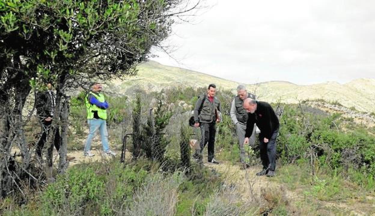 El antropólogo forense señala el lugar donde encontró el premolar ante la atenta mirada de dos guardias civiles. 