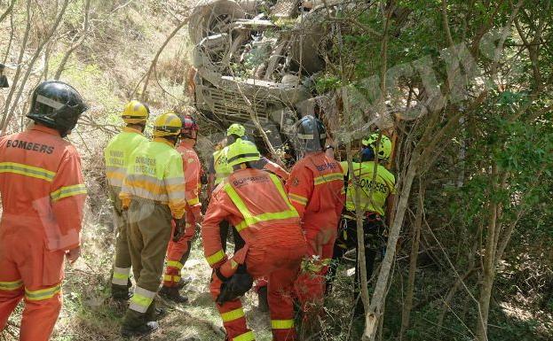 Imagen principal - Dos obreros mueren al caer su grúa por 40 metros tras ceder una ladera