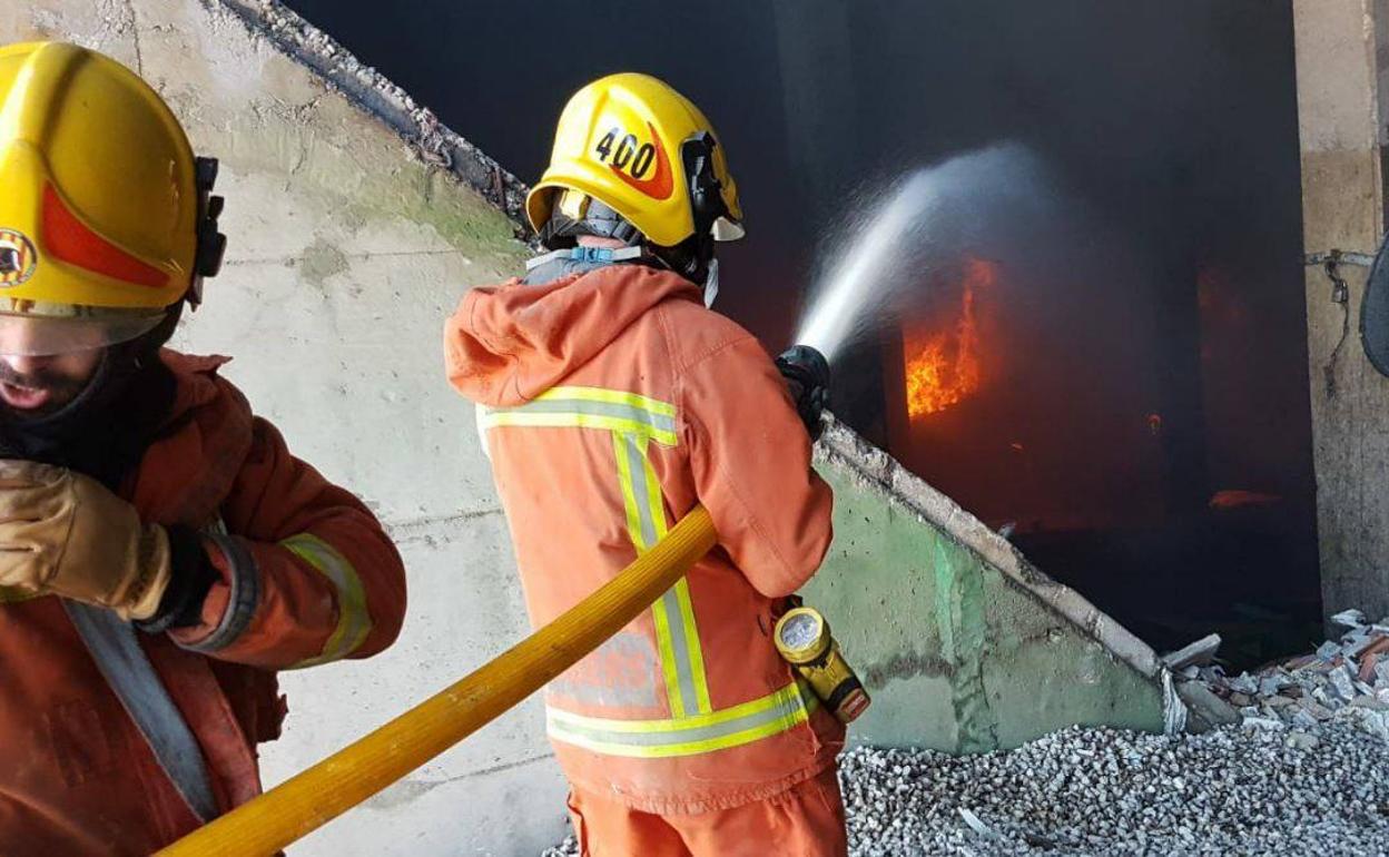 Efectivos sofocando el fuego de la planta de reciclaje de Guadassuar.