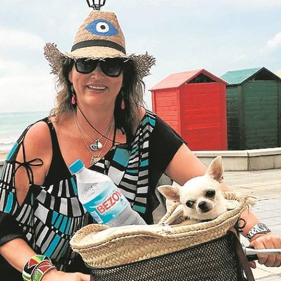 Delia Barral en bici con su perro en el paseo de la playa de la Almadraba.