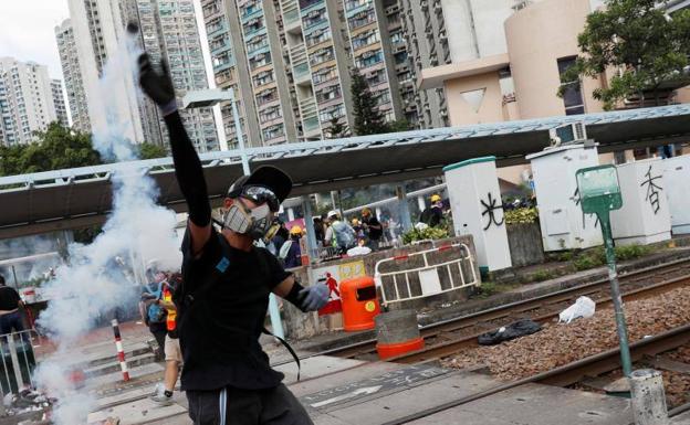 Un manifestante devuelve a la policía un bote de gas lacrimógeno durante las protestas.