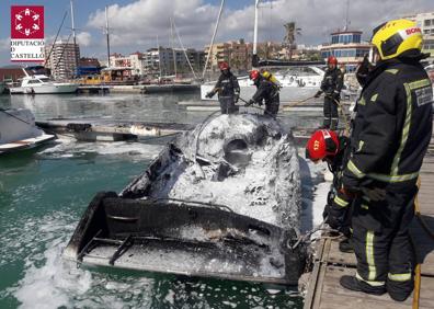 Imagen secundaria 1 - Actuación de los bomberos extinguiendo el incendio de la embarcación. 