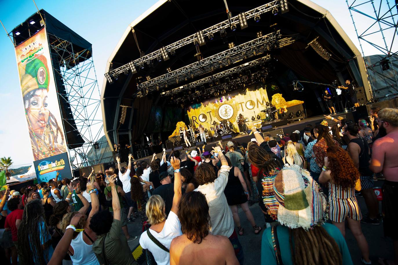 La 26 edición del certamen internacional reggae Rototom Sunsplash ha arrancado y ha convertido a la localidad castellonense en la capital mundial del reggae y en epicentro cultural, con dosis extra de compromiso medioambiental. La apuesta ofrece, hasta el próximo día 22, cien conciertos en siete escenarios por los que pasarán artistas de 23 nacionalidades. La cita, que cumple su primera década en España tras aterrizar desde Italia en el verano de 2010, trae ritmos que van desde el reggae, el dancehall o el dub, a la música de raíces negras, la música más profundos del Caribe, pasando por las sesiones de dj a ritmo de afrobeat y coupé-décalé. El festival recibirá a exponentes jamaicanos como el ganador del Grammy e hijo de Bob, Ziggy Marley o a la familia del reggae moderno: Morgan Heritage. También acudirán leyendas del reggae como el grupo The Abyssinians, -que cumple 50 años- entre otros.