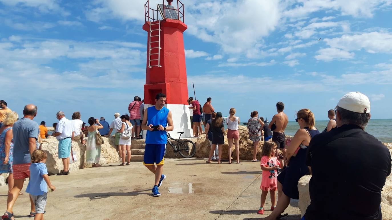 Vecinos se asoman al puerto de Dénia para ver los trabajos de rescate del ferry encallado