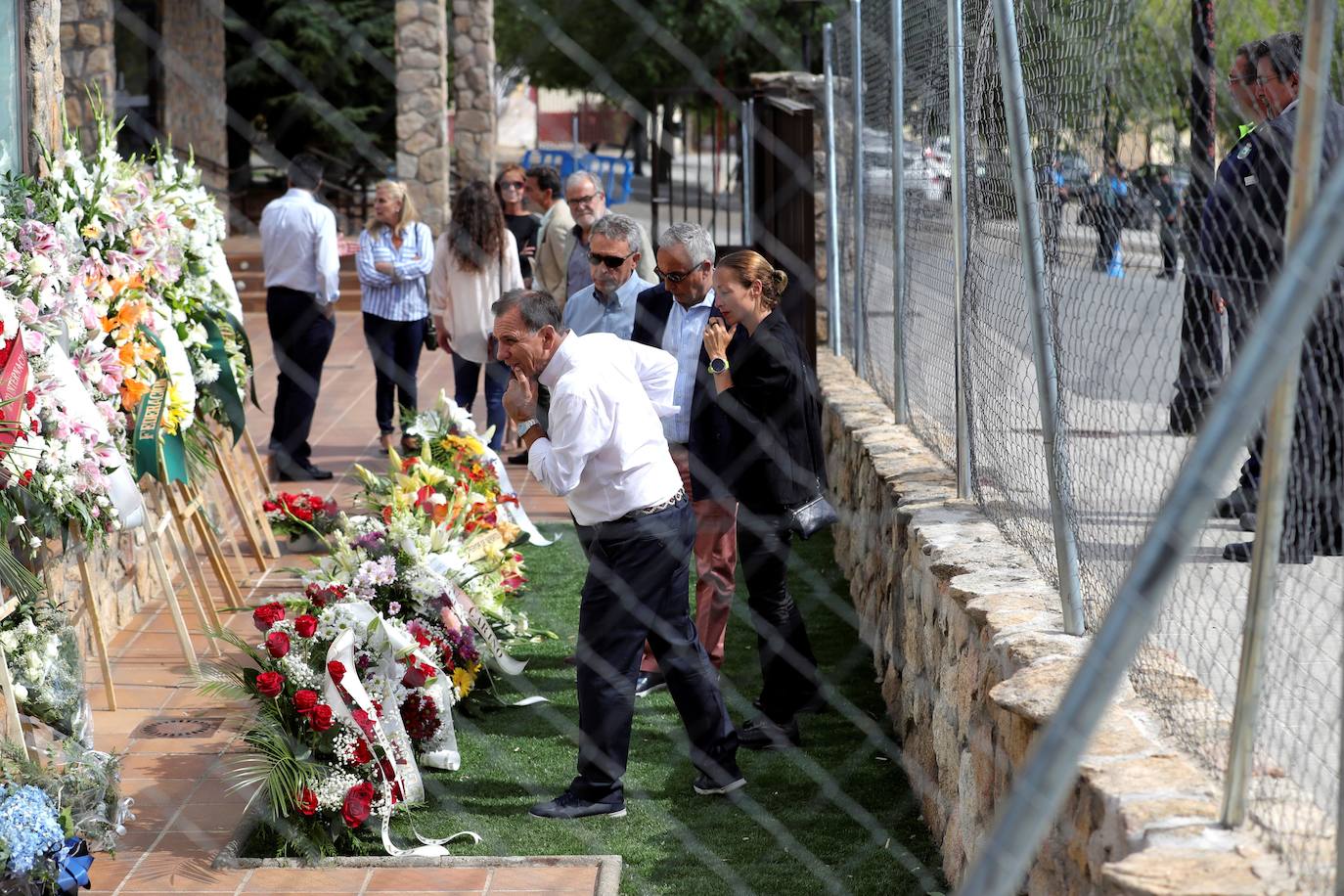 El presidente del Comité Olímpico Español Alejandro Blanco (2d), Paula (d), hija del campeón olímpico Paquito Fernández Ochoa, y Adrián Federighi (4d), cuñado de Blanca Fernández Ochoa, observan las coronas de flores en la capilla ardiente.