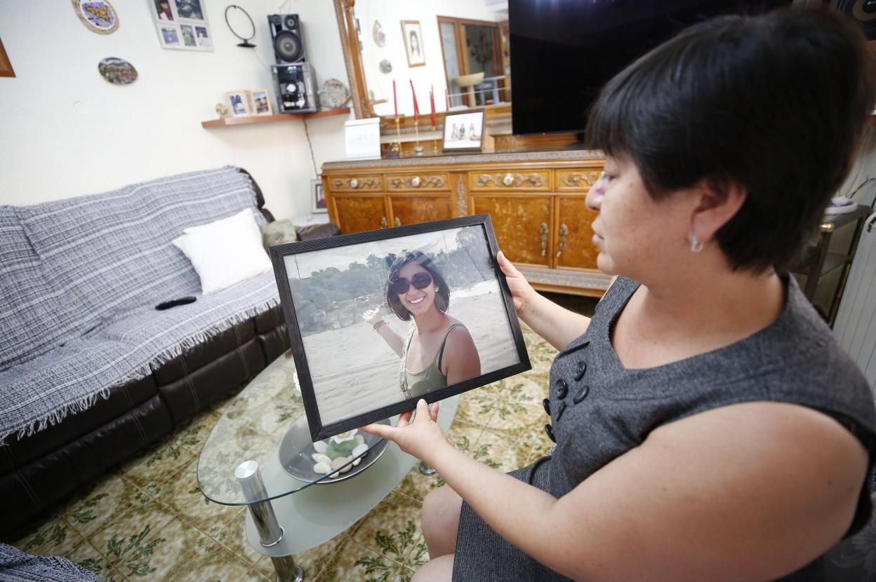 Alejandra Ayala contempla una fotografía de su hija, ayer, en su casa del barrio valenciano de Patraix. 