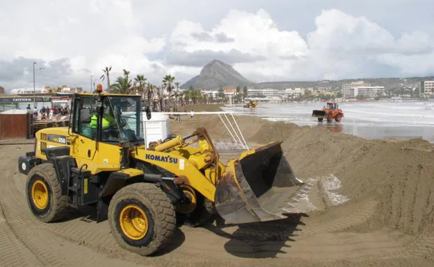Construcción del muro de arena en el Arenal de Xàbia para evitar que el agua del mar se trague la playa y destroce las terrazas.