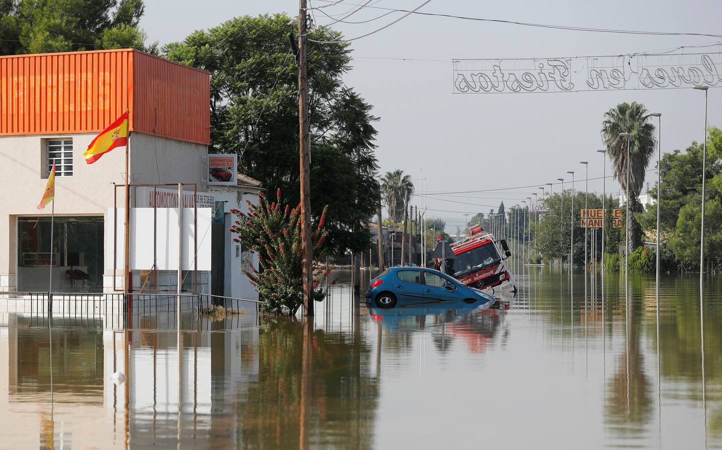 Negocios, coche y un camión de bomberos, en mitad del agua.