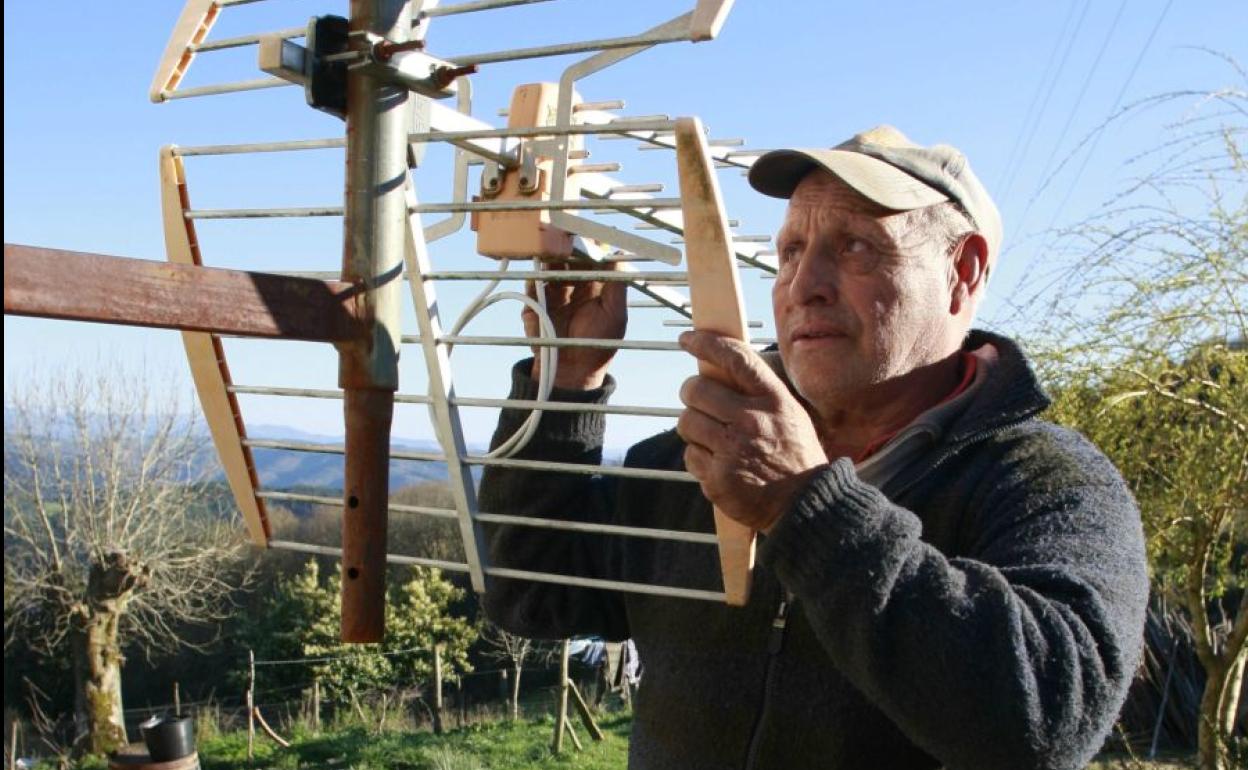 Un hombre reorienta su antena de televisión. 