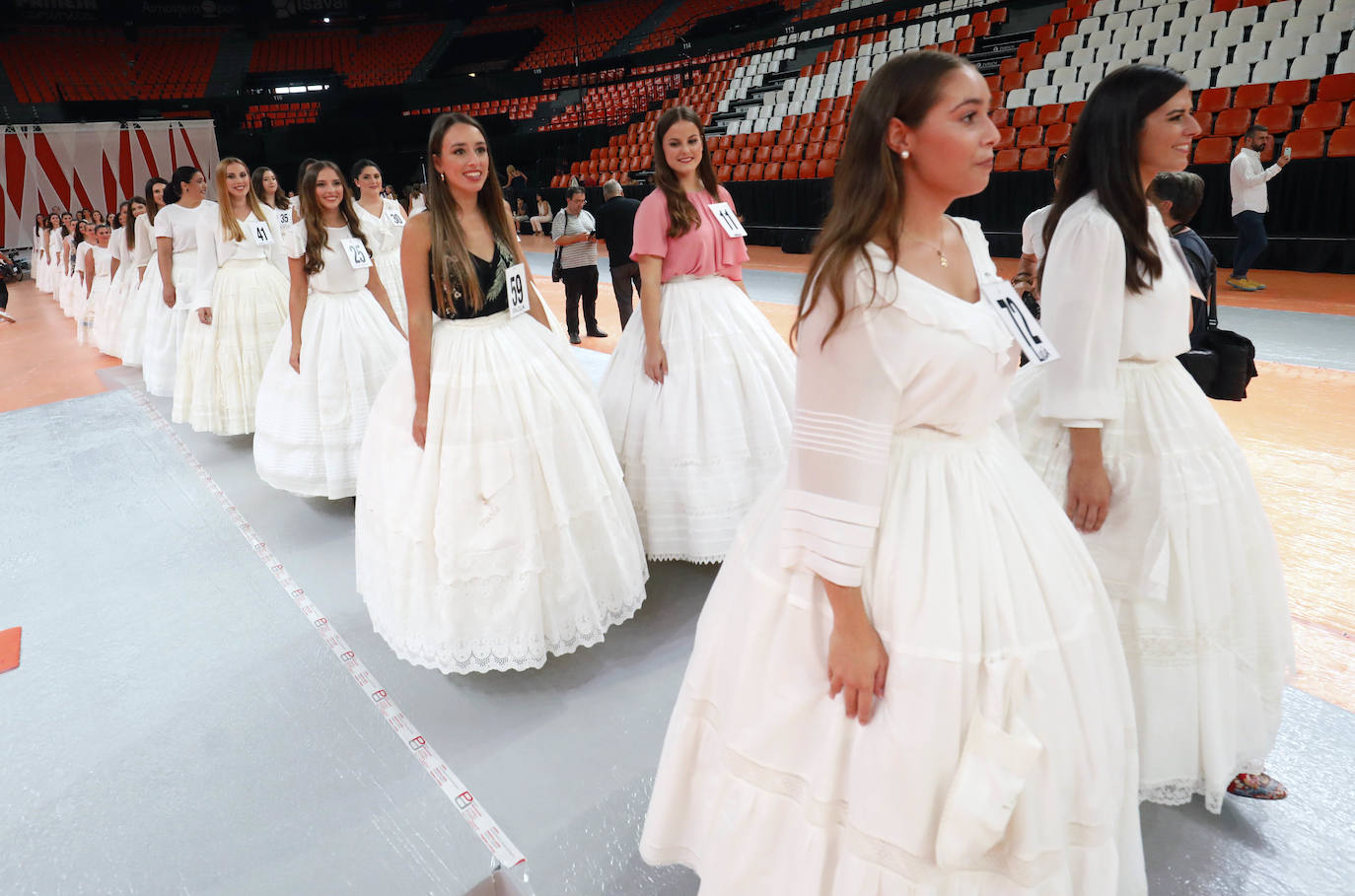 El pabellón de la Fonteta acogió ayer una jornada de ensayo de las 73 candidatas mayores y 73 niñas que optan a formar parte de las cortes de honor de 2020. Todas ellas tomaron asiento en las gradas y, posteriormente, desfilaron de forma ordenada con el número que las identifica ante la atenta mirada de los jurados, que estaban tomando buena nota de la puesta en escena. Con las habituales enaguas de la indumentaria valenciana y con una blusa o chaqueta y con los zapatos de valenciana, todas ellas mostraron su mejor sonrisa y no dudaron en aflorar los nervios típicos antes de la gala del sábado. La escuela de danza de Susana Renau y los falleros que colaborarán en el espectáculo también repasaron los números.