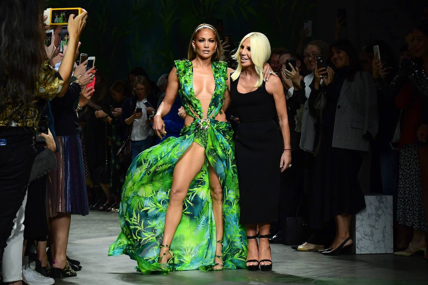 La cantante y actriz latina estadounidense Jennifer López causó sensación este viernes en la pasarela de Milán al desfilar para Versace, una sorpresa en el cierre de un certamen que se dejó llevar por la selva amazónica de la mano de Marni. Reina de la gala con un espectacular vestido de seda verde muy escotado, el mismo modelo que corto el hipo en la ceremonia de los Grammy del año 2000, JLo demostró su poder en una sala al borde de la histeria.